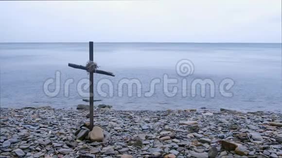 在阴天的时候岩石海滩上用木棍交叉的海景视频的预览图