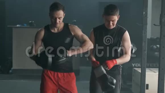 教练和拳击手正在准备在健身房训练运动员去戴拳击手套4K慢动作视频的预览图