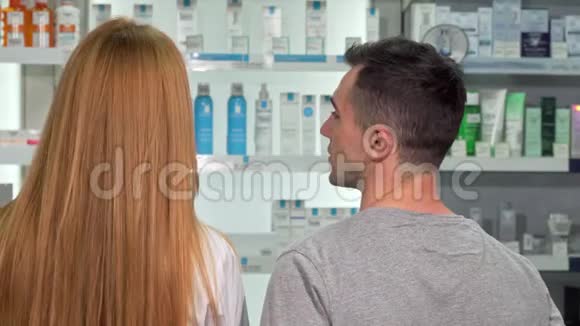 一位药剂师和顾客在药店交谈时的后视镜视频的预览图