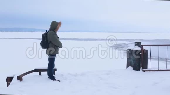 人们在冰冻的河水中喝热水瓶里的茶视频的预览图