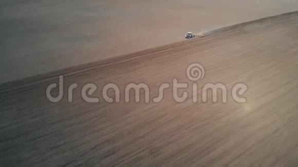 无人机飞过耕田的拖拉机视频的预览图