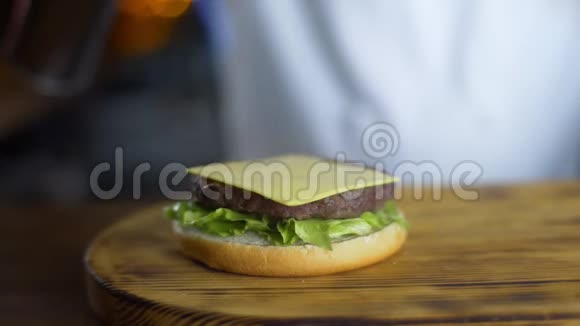 厨师在餐厅制作汉堡快餐烹饪过程中在切块上用燃气燃烧器融化奶酪视频的预览图
