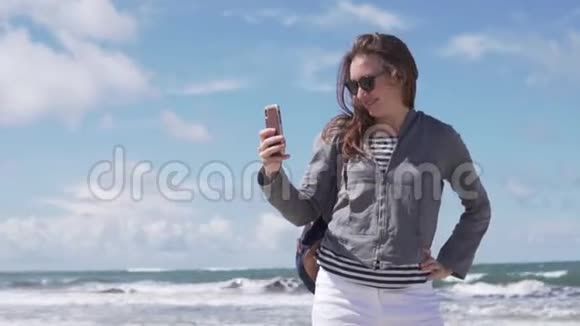 一位游客在大海的背景上打电话自拍视频的预览图