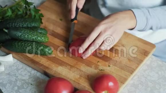 在木板上用刀切番茄把女人的手收起来概念蔬菜视频的预览图