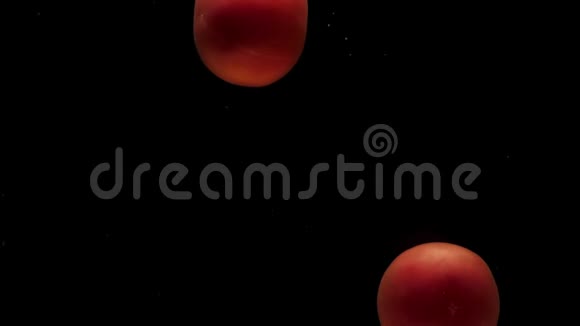 两个红色的假名躺在透明的水里黑色的背景视频的预览图