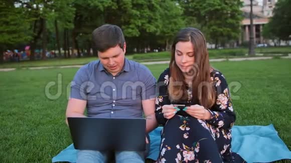 年轻英俊的已婚夫妇用笔记本电脑和信用卡在线购物视频的预览图