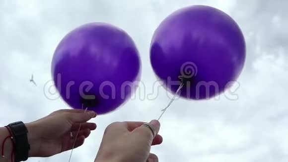 两个紫氦气球飞向天空视频的预览图