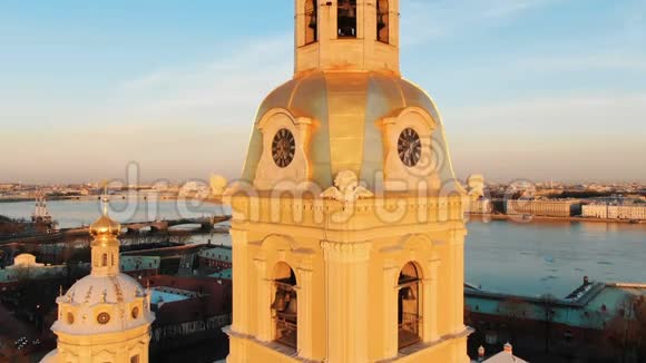 日落时分彼得和保罗堡的大教堂顶部和钟楼的空中飞行圣彼得堡视频的预览图