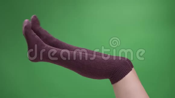 特写侧景拍摄女青少年腿在可爱的红色袜子嬉戏移动与后轮孤立在绿色视频的预览图