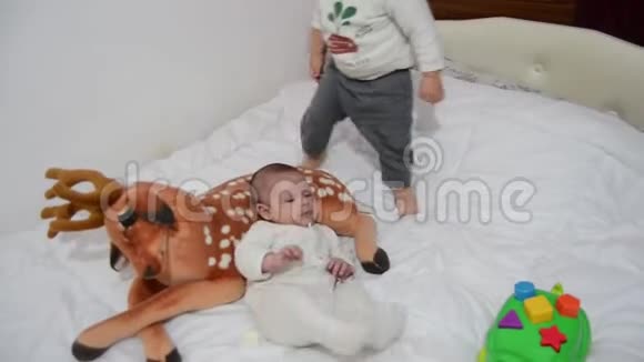 幼儿试图从躺在上面的弟弟手里偷走亲爱的软玩具视频的预览图