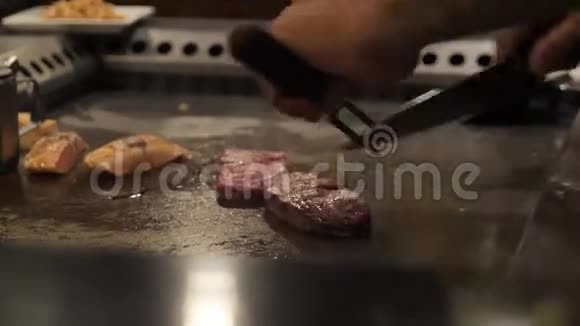亚洲厨师在一个大炉子上为观众切肉视频的预览图