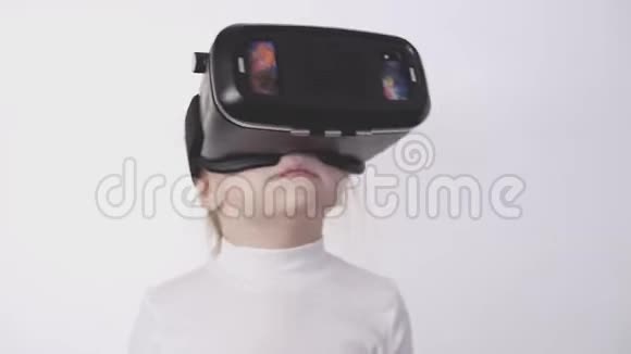 穿着白色衬衫的金发小女孩看360视频戴着VR耳机视频的预览图