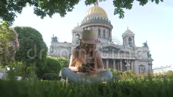 少女游客坐在城市街道上度假时用智能手机搜索信息技术休闲视频的预览图