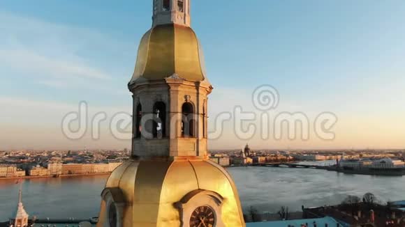 日落时分在圣彼得堡历史中心的彼得和保罗堡钟楼周围的空中拍摄视频的预览图
