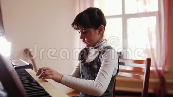一个小女孩坐在钢琴旁合上了钢琴视频的预览图