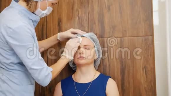 美容诊所的女人专家擦拭客户面部视频的预览图