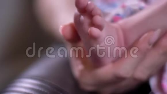 妈妈抱着婴儿小脚丫和手指在客厅的特写镜头视频的预览图