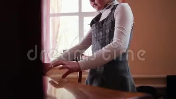 一个小女孩打开一个钢琴封面开始演奏视频的预览图