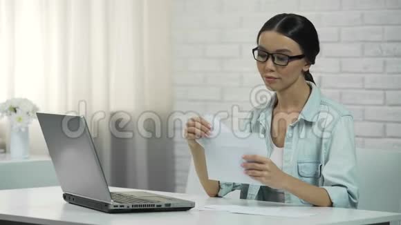 妇女在家里用笔记本电脑打字付水电费或检查信件视频的预览图