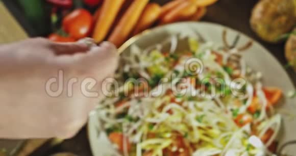 一只手把盐洒在上面看到的沙拉上视频的预览图