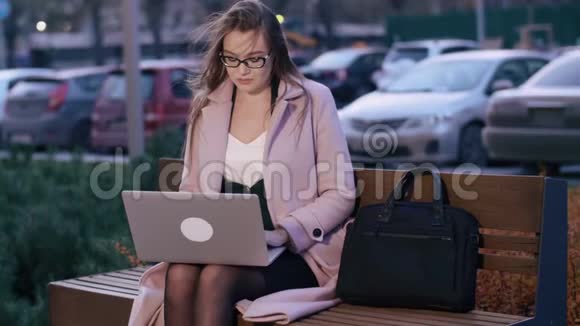 女性自由职业者集中精力晚上在户外的笔记本电脑上做远程工作视频的预览图