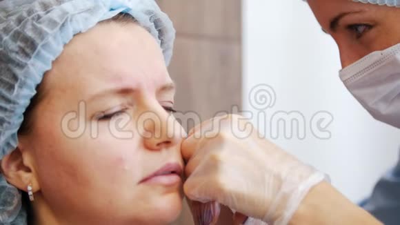 美容诊所的女人专家在客户的眼皮底下扎针视频的预览图