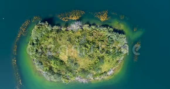 空中飞行离开山谷湖中央的一个岛屿视频的预览图