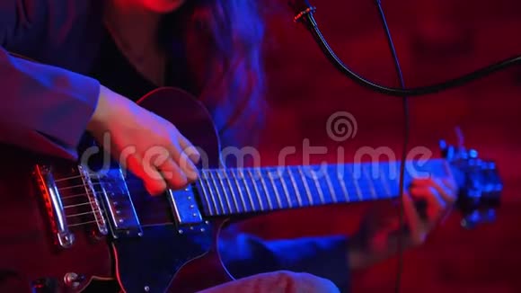一个年轻的女人在霓虹灯中弹着吉他和唱歌视频的预览图