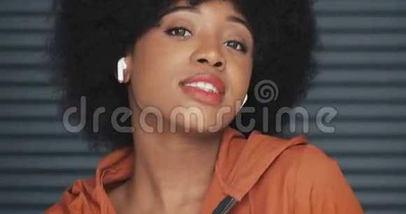年轻快乐的非洲裔美国妇女戴耳机听音乐跳舞的镜头视频的预览图