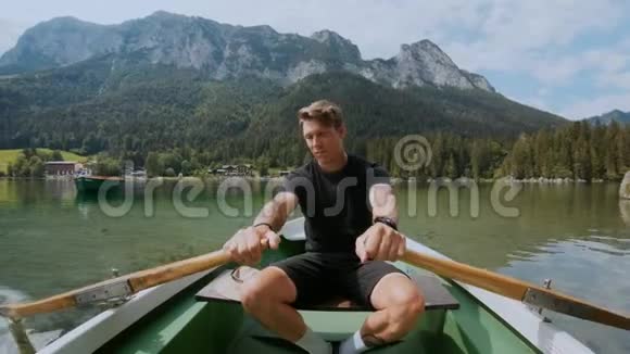 英俊的男人在湖边划船视频的预览图