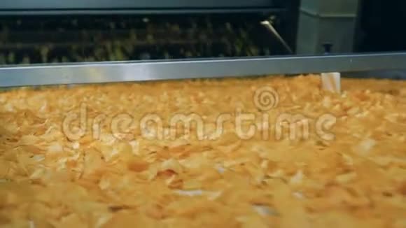许多油炸薯片在食品生产设施的自动输送机上移动视频的预览图