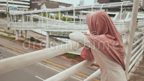 雅加达市中心的一座桥上站着一个年轻而悲伤的穆斯林女孩印度尼西亚录像正在播放视频的预览图