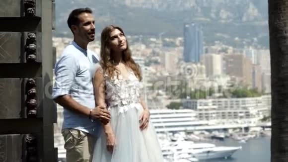 丈夫在城市的背景下拥抱妻子行动年轻漂亮的夫妇拥抱在城市景观的背景下新婚夫妇视频的预览图