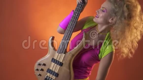 一个穿着复古服装摇着头发用吉他跳舞动作缓慢的女人视频的预览图