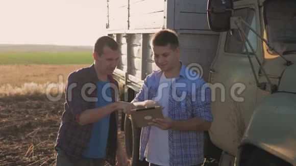 农民田间劳作交流看碑两个农民在田间交谈用平板电脑农民颤抖视频的预览图