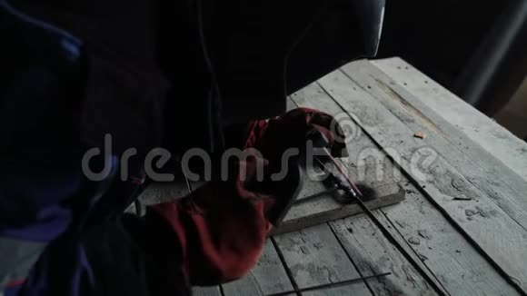 从一侧乙炔焊工在焊接面罩焊接两个金属部分视频的预览图
