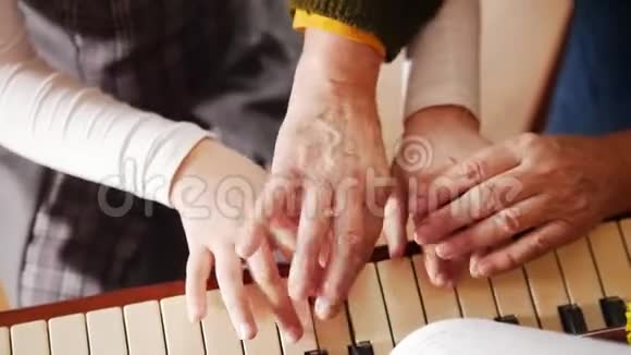 音乐课女孩弹钢琴年长的老师站在她身边帮助演奏从顶部看视频的预览图