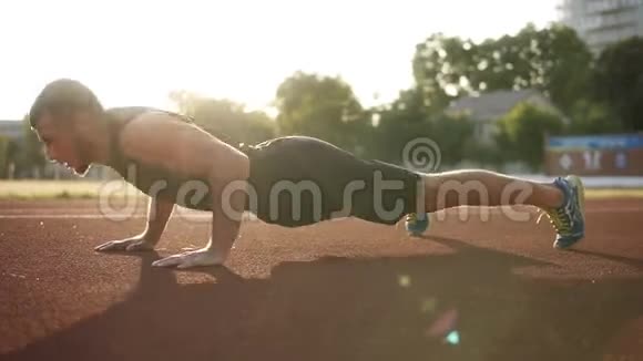 长胡子的肌肉男做俯卧撑男运动员在户外运动在球场上健康生活方式视频的预览图