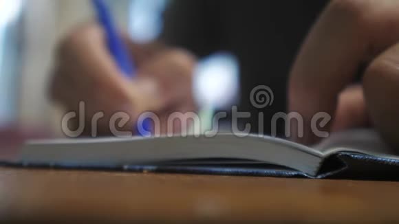人在笔记本上写字男人手写记事本概念商业教育男人在生活方式上做笔记视频的预览图