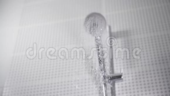 浴室里从淋浴喷头流出的水集中在缓慢运动的水滴上视频的预览图