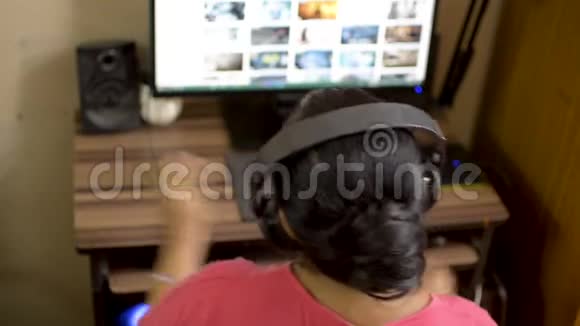 印度亚裔白种人女女孩穿着粉红色的t恤在家里听着戴着耳机听音乐关闭视频的预览图