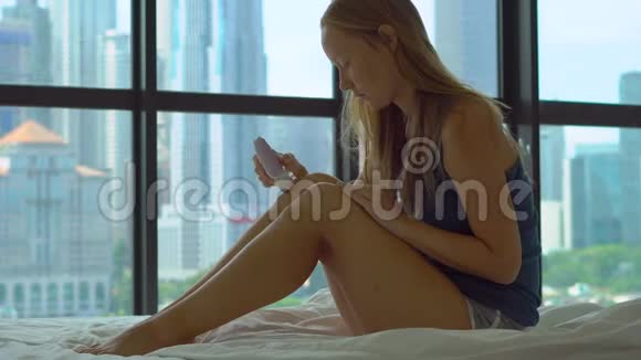 一位躺在床上的年轻女士用电动扩张器刮腿视频的预览图