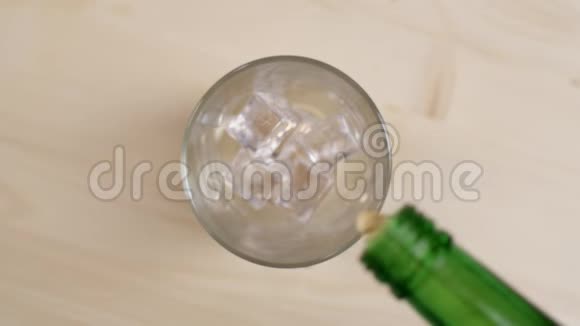 将酒精饮料倒入装有冰块的木桌玻璃中威士忌饮料的俯视图视频的预览图