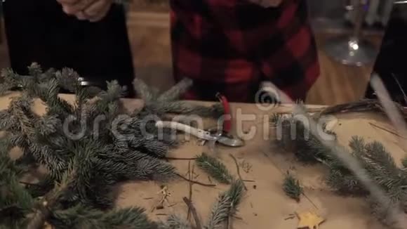 女性手为圣诞花环整理松枝视频的预览图