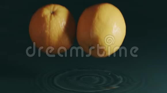 两个桔子溅在水里慢镜头红色镜头视频的预览图