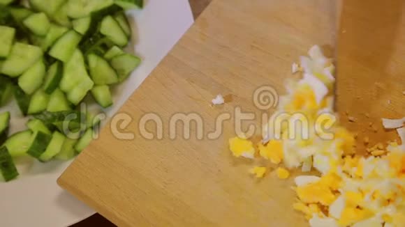 一个拿着刀的女人把一个切好的鸡蛋放在盘子里上面放着黄瓜片视频的预览图