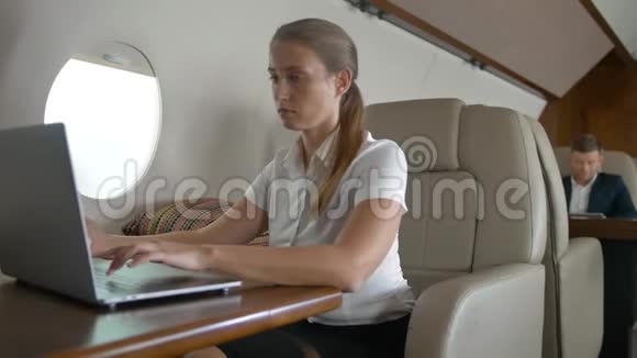 在飞机上使用现代智能手机的年轻女性肖像视频的预览图