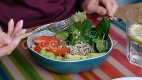 女人正在吃五颜六色的健康午餐盛有蔬菜和种子的碗健康食品理念视频的预览图