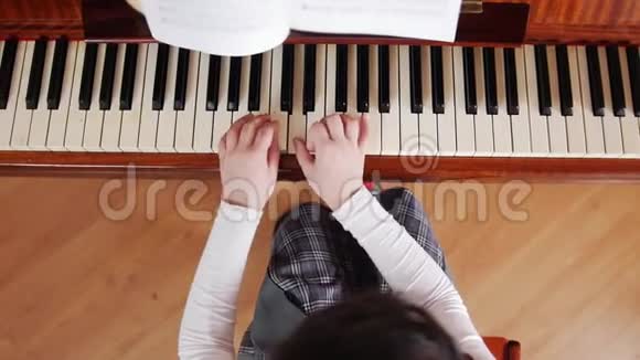 音乐课女孩学弹钢琴俯视图视频的预览图