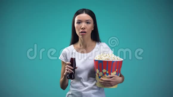 电影中女人喝汽水吃爆米花看电影的情节视频的预览图